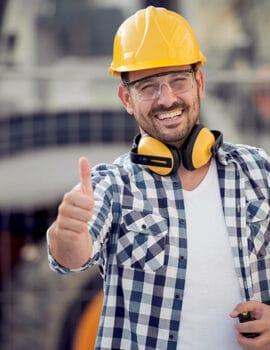 Portrait of a worker in factory Portrait of a cheerful male architect wearing hardhat and showing thumbs up.