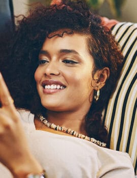 I use my blog to inspire people to follow their dreams Shot of an attractive young woman using her cellphone while relaxing on the sofa at home